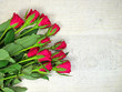 A bouquet of red roses on a wooden light background
