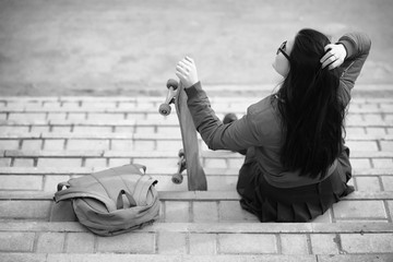 A young hipster girl is riding a skateboard. Girls girlfriends f