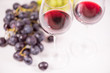 © noxnorthy - Fresh grape and red wine on the white table with two glasses, selective focus