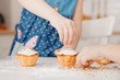 © Parilov - Children with their hands sprinkle cupcakes with colored caramel for Easter. Concept happy family.