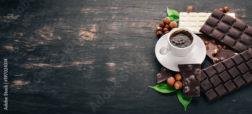 Zdjęcie XXL Filiżanka kawy i zestaw czekolady z ciasteczkami i słodyczami. Na czarnym tle drewnianych. Widok z góry. Skopiuj miejsce na tekst.