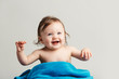 © Photocreo Bednarek - Toddler with a cozy blanket sitting and smiling.