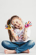 © Photocreo Bednarek - Happy girl covered in paint sitting on the floor.