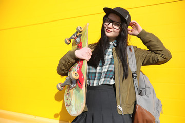 A young hipster girl is riding a skateboard. Girls girlfriends f