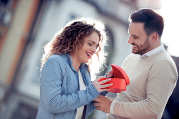 Wall Mural - Smiling boy giving to his girlfriend a gift