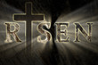 Easter background with Jesus Christ cross and risen text written, engraved, carved on stone, with light coming from behind. Christian, religious Easter card. resurrection, belief, new life concept 