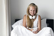 © AnastazjaSoroka - Happy morning. Young woman listen music in white bed.
