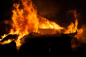 Burning fire flame on wooden house roof