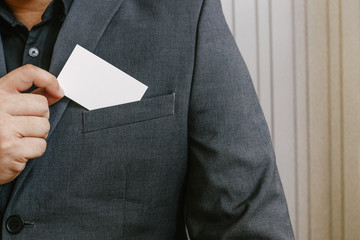 Wall Mural - Man holding white business card,Man wearing blue shirt and showing blank white business card. Blurred background. Horizontal mockup, Smart asian business Person Professional Occupation cheerful