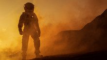 Brave Astronaut Confidently Walks On Mars Surface. Red Planet Covered In Gas And Rock,  Overcoming Difficulties, Important Moment For The Human Race.