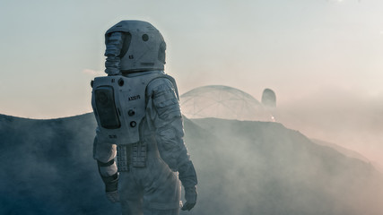 Wall Mural - shot of the astronaut on red planet watching toward his base/research station. near future first man