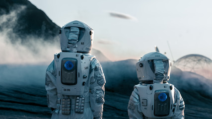 Wall Mural - shot of two astronauts confidently walking on alien rocky planet that is covered with gas and smoke.