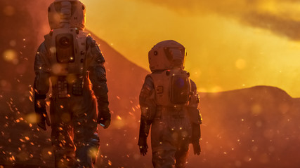 Wall Mural - two astronauts wearing space suits exploring high temperature venus/ red planet during fire storm/ s