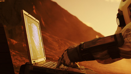 Wall Mural - astronaut on the alien red planet/ mars works on laptop with graphical ui. space exploration, findin