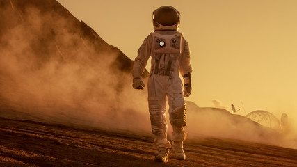 Wall Mural - brave astronaut confidently walks on mars surface. red planet covered in gas and rock, overcoming di