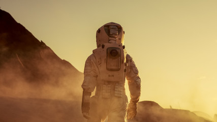 Wall Mural - shot of astronaut confidently walking on mars. red planet covered in gas and smoke. humans overcomin