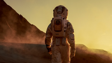 shot of astronaut confidently walking on mars. red planet covered in gas and smoke. humans overcomin
