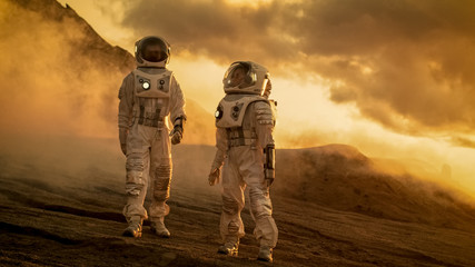 Wall Mural - two astronauts in space suits confidently walking on mars, exploration expedition on the planet's su