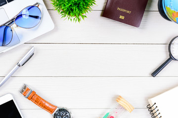 The worker and employee desk has trip dreaming and preparing to journey and travel around the world with laptop and passport on white wood table from flat lay top view.