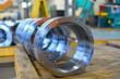 © andov - New cylindrical parts after machining on the lathe and CNC milling machine lie on a wooden rack in the shop.