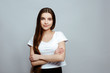 © Мария Балчугова - human emotions. Portrait of the young beautiful woman brunette with long dark brilliant hair. The girl poses on a white background, standing with folded arms and smiling