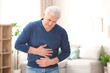 © New Africa - Mature man suffering from stomach ache at home