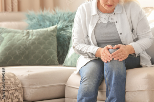Cuadros en Lienzo Mature woman suffering from knee pain at home