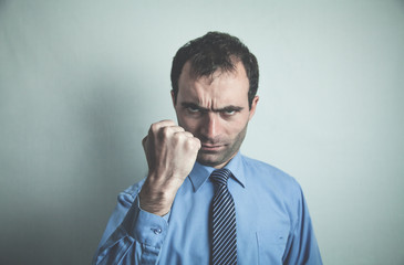 Wall Mural - Caucasian angry businessman on gray background.