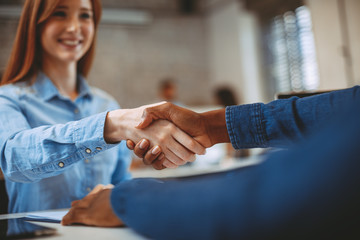 Wall Mural - Young woman signing contracts and handshake with a manager