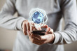 © ARAMYAN - Businessman holding digital globe with mobiel phone