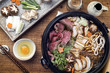 Traditional Sukiyaki pot with Kobe Beef and Vegetable as close-up on wooden table