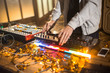 © Seventyfour - Unrecognizable DJ standing at mixer and playing trendy music at dim night club, close-up shot