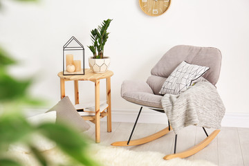 Wall Mural - Modern rocking chair and tropical plant with green leaves in stylish room interior