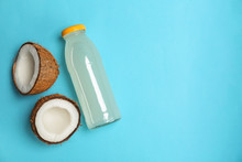 Bottle Of Coconut Water And Fresh Nuts On Color Background
