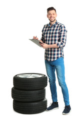 Wall Mural - Young man with car tires on white background