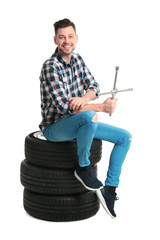 Wall Mural - Young man with car tires on white background