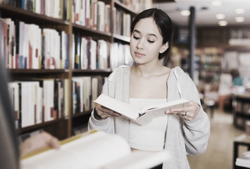 Wall Mural - girl browsing textbooks in bookstore