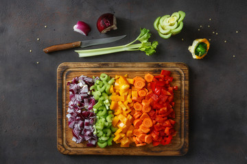 Wall Mural - Top view chopped vegetables serving on cutting board on dark background