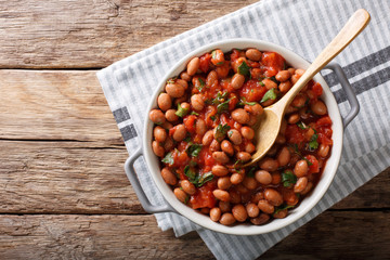 Wall Mural - Stewed cranberry beans or borlotti in tomato sauce with herbs close-up in a bowl. horizontal top view from above