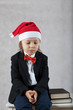Boy in Santa's hat and black classical jacket.