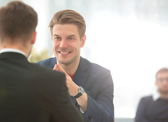 Two men discuss the growth of the company, looking at the rising graph on a computer screen