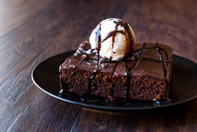 Chocolate Brownie With Ice Cream And Hazelnut Powder.