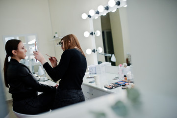 Wall Mural - Make up artist work in her beauty visage studio salon. Woman applying by professional make up master. Beauty club concept.