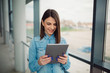 © Nebojsa - Happy european business woman using a tablet computer. Female financier is reading financial news on the internet via touch pad. Confident woman lawyer is using digital table.