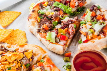 Homemade Mexican Taco PIzza with Nachos  chips, beans, fresh vegetables, beef meat, copy space