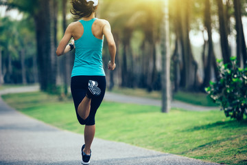 sporty fitness woman running at tropical park