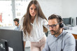 © Bojan - Customer support workers solving problems together on client's online account in call centre office.