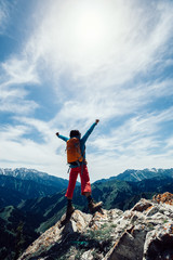 Wall Mural - successful Hiker outstretched arms stand at cliff edge on mountain top