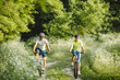 © sergo321 - a woman and a man cycling in summer in the park on bicycles