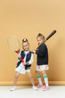 © master1305 - Portrait of two girls as tennis players holding tennis racket. Studio shot.